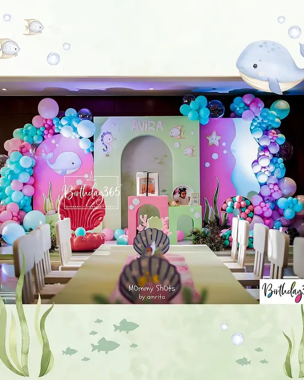 We created a magical underwater world for Avira's 2nd birthday. The setup featured a long dining table for the little guests, a colorful backdrop with whale and seahorse details, and vibrant balloon arches.