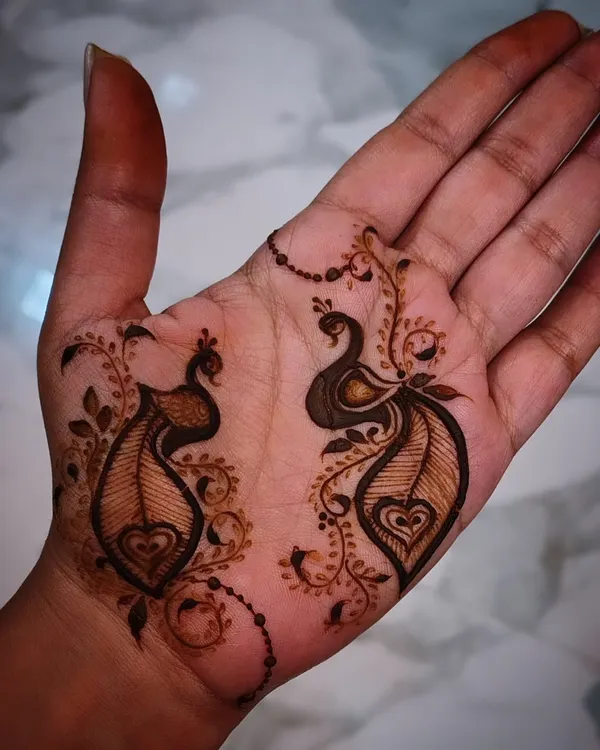 A very simple and sweet design featuring two small peacocks on the palm. This kind of minimalist art is perfect for someone who wants just a touch of henna.