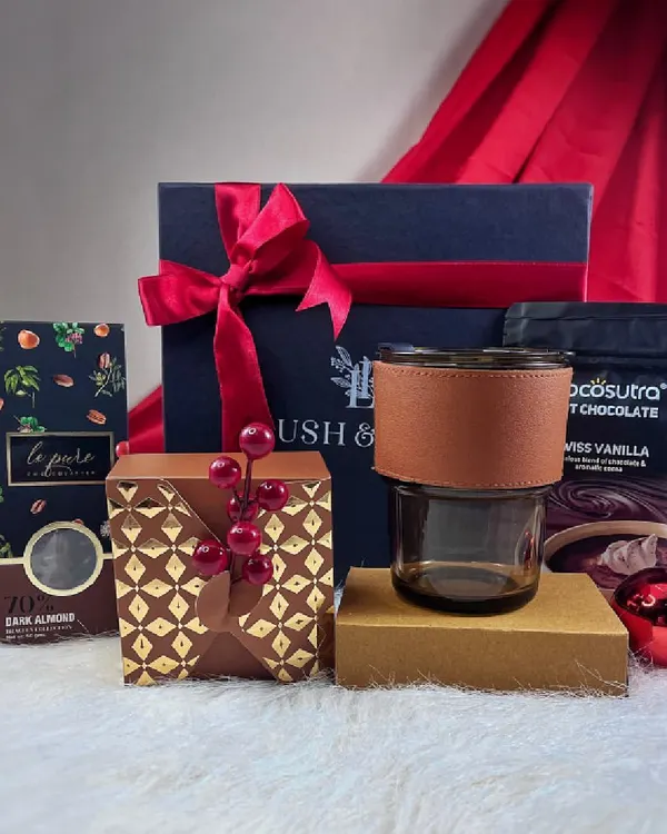 Our "Cozy at Home" Christmas hamper, featuring hot chocolate mix, dark almond chocolate, and a stylish glass tumbler. It's the perfect gift to send warm wishes during the holiday season.