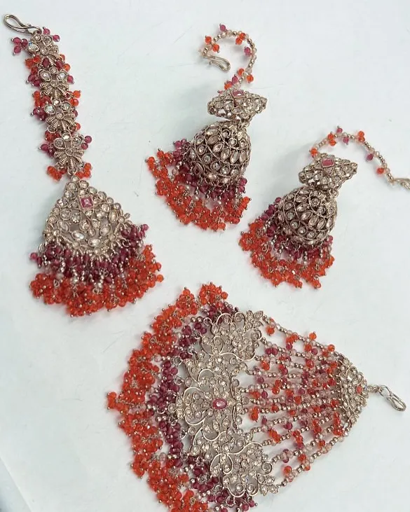 A beautiful rental set from my Mehendi and Haldi collection. This set features a maang tikka, hathphool, and jhumka earrings with red and orange beads.