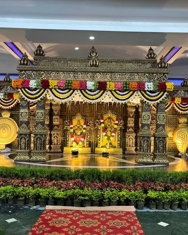 This grand temple-style mandap is one of my signature creations. The intricate pillars, traditional carvings, and vibrant floral garlands create a truly magnificent and sacred space for a wedding ceremony.