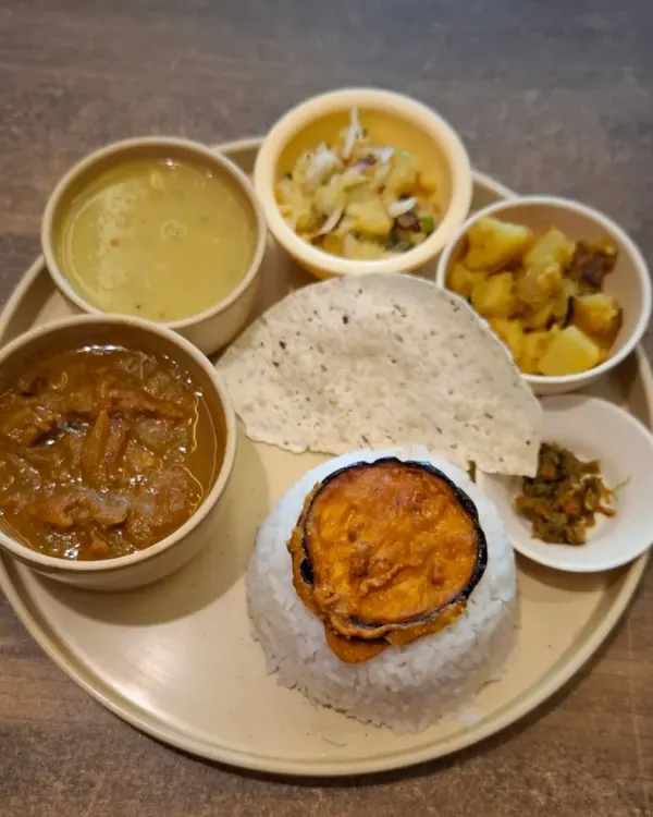 A classic Axomia style chicken thali. It features fragrant Joha rice, our simple dal, mashed Aloo Pitika, and crispy Begun Bhaja, all centered around a hearty chicken curry.