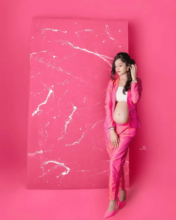 A bold and modern maternity look! This mom-to-be is absolutely glowing in a hot pink pantsuit, proving that pregnancy style can be fun, fashionable, and powerful.