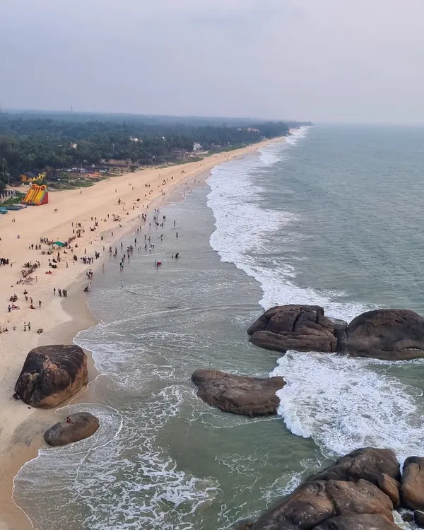An aerial view of the stunning coastline at Kapu Beach near Udupi. The vast expanse of sand, sea, and the distant lighthouse makes for a breathtaking sight.