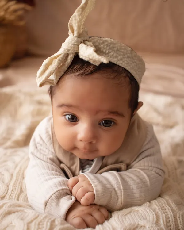 Just the baby. A simple, close-up portrait of a beautiful newborn with the most soulful eyes, captured on a soft, textured blanket.