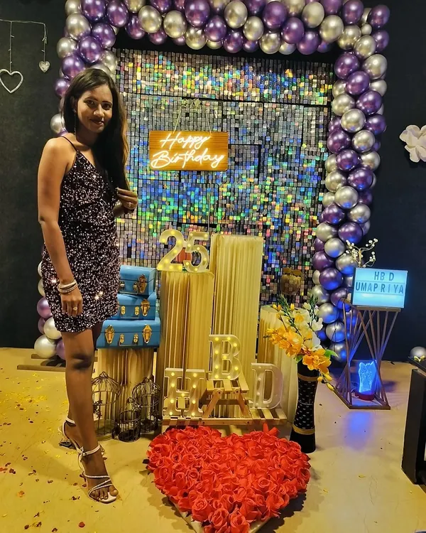 Turning 25 in style. This picture captures our popular purple and silver decor theme, complete with a neon 'Happy Birthday' sign, a heart made of roses, and personalized light-up letters.