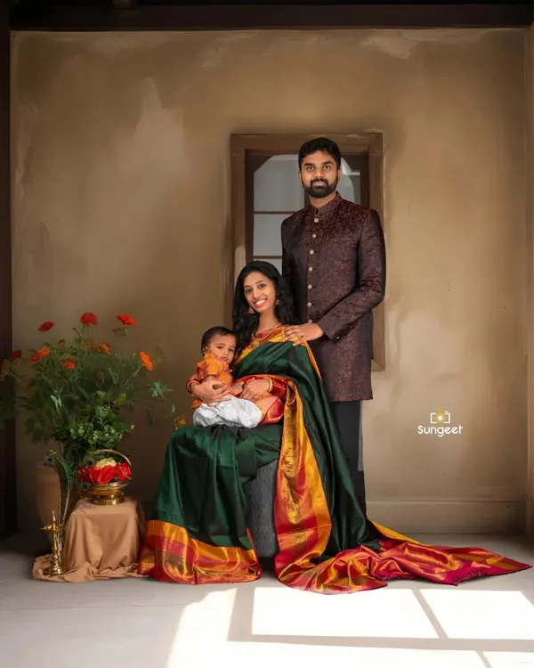 A beautiful family portrait celebrating their second journey to parenthood. The mother, dressed in a traditional silk saree, holds her toddler, creating a warm and complete picture of their growing family.