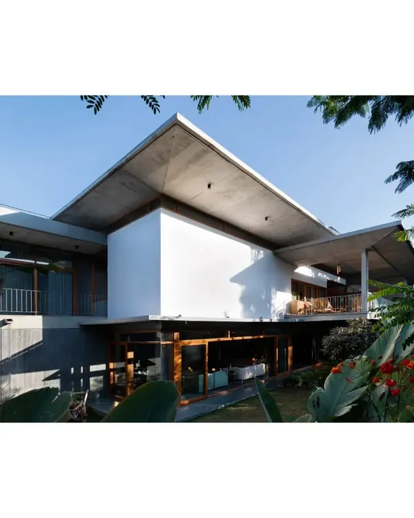This is the House of Canopies, a biophilic home in Bangalore where cantilevered concrete roofs create deep, protective overhangs. We designed these not just as shelter, but as elements that sculpt light and frame views, connecting the home's raw concrete structure with the lush garden surrounding it.