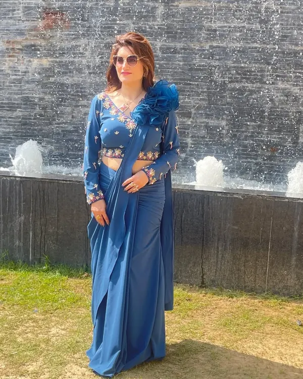 I'm wearing one of my favorite creations, a blue pre-stitched drape saree. It has the grace of a saree and the comfort of a gown, with a beautifully embroidered blouse and a 3D floral detail.