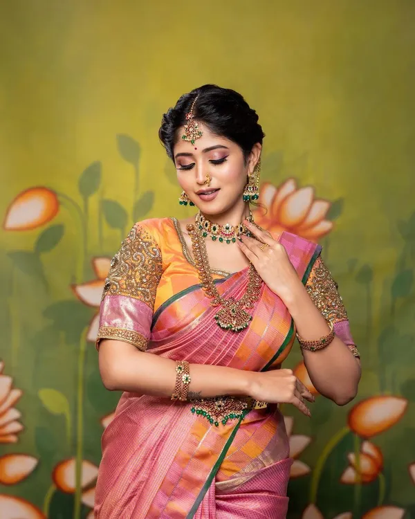 A beautiful shot from a portfolio session. This look features a colorful Kanjivaram saree, traditional temple jewellery, and a soft, romantic makeup application with a focus on pink tones.