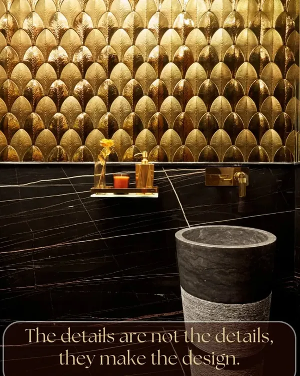 The details are not just details; they make the design. This powder room is a testament to that philosophy, with golden fish-scale tiles, a black marble pedestal sink, and perfectly matched fixtures creating a luxurious and cohesive look.