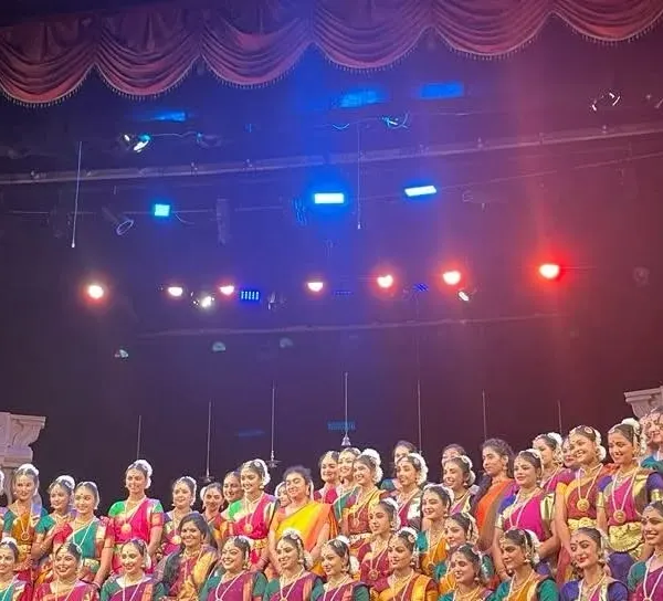 This is my family, my pride. Here we are, over 200 of my students from three branches, united on stage for our 19th annual day, 'Nrithya Milana'. This picture captures the scale and spirit of our large group Bharatanatyam performances.
