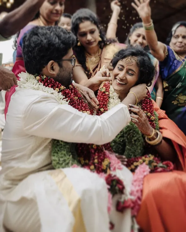 This is the kind of moment I live for. The air filled with blessings and flower petals, and a smile of pure, unscripted joy during the Thali tying ceremony. It’s these real emotions that turn a wedding day into a timeless story.