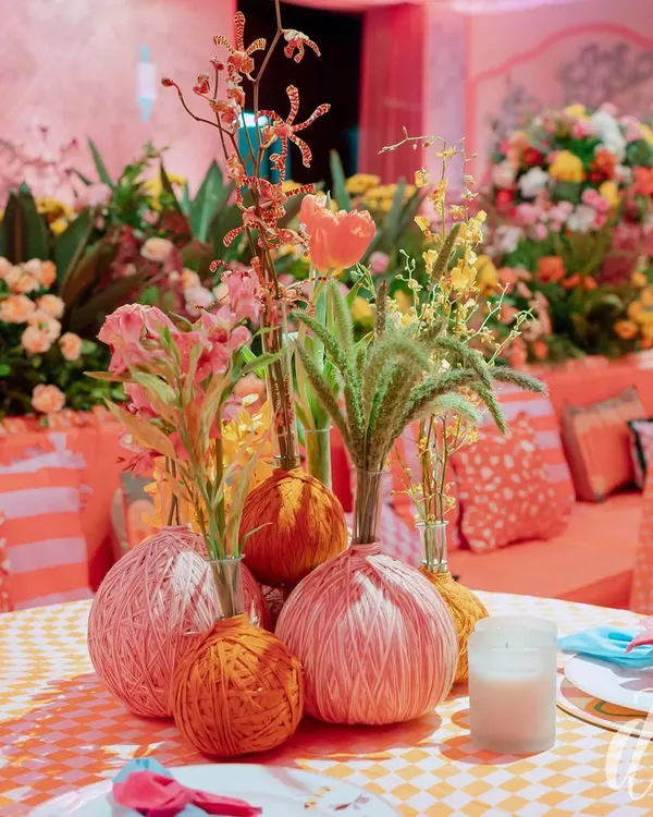 For our 'La Dolce Vita' theme, we created these unique centerpieces by mixing fresh flowers with textured yarn-wrapped spheres, adding a playful and crafty element to the tablescape.