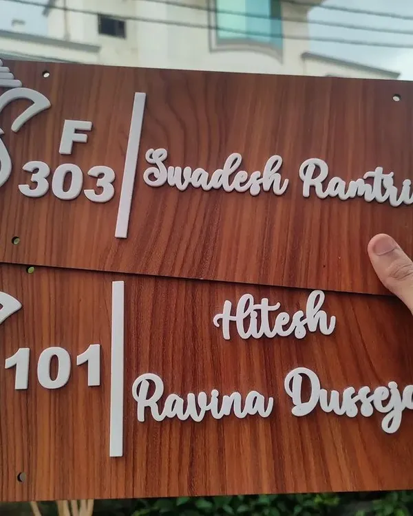 A pair of custom wooden door nameplates ready for delivery. I can customize the names, flat numbers, and even the Ganesha design to match your style.