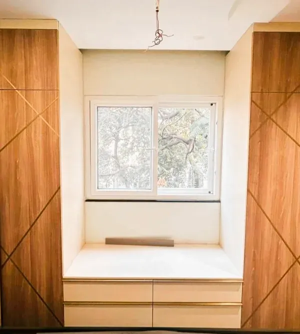 This project perfectly illustrates our multi-functional approach. We built a complete storage wall with twin wardrobes flanking a comfortable bay window seat with built-in drawers.