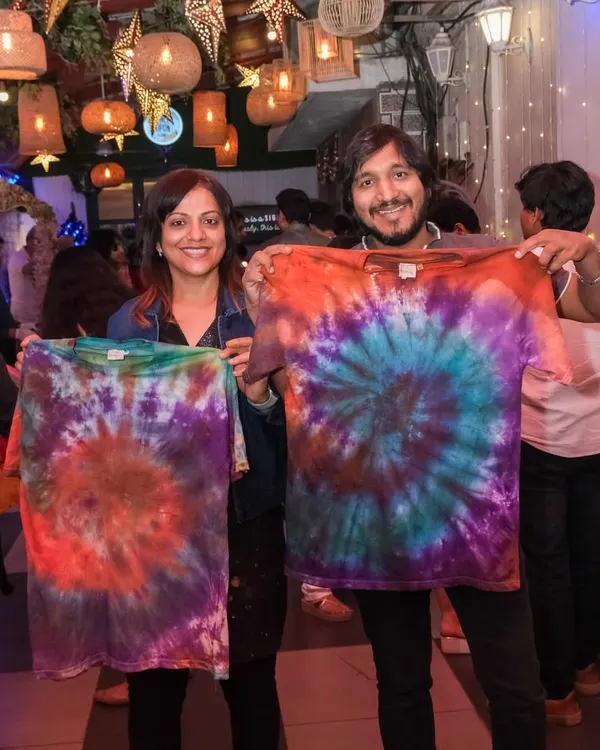 A happy couple shows off the vibrant, matching tie-dye shirts they created in one of my fun and colorful craft workshops.