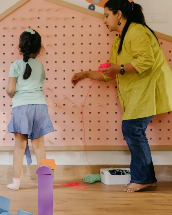 This is our Makerspace, a hub where children can invent, tinker, and design. A child and teacher work together on a large weaving board, developing fine motor skills and collaborative problem-solving.