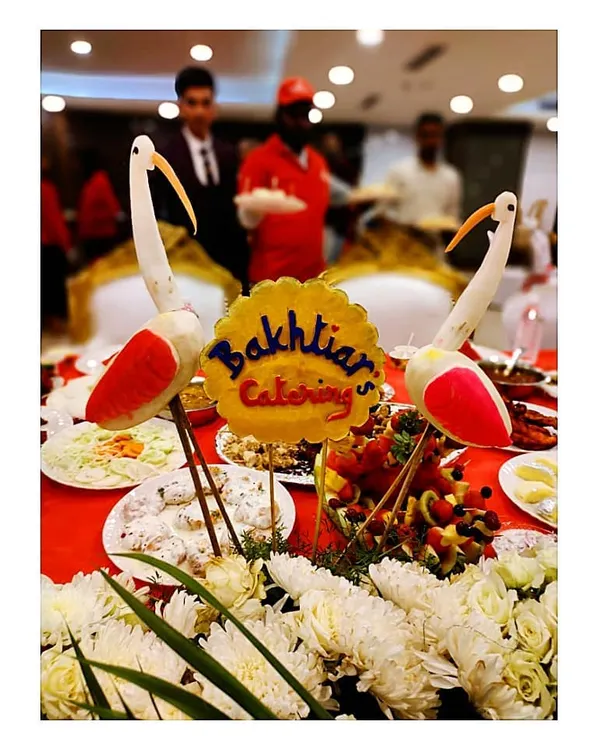 Our branding takes center stage in this beautiful table centerpiece, featuring our name carved from fruit and flanked by elegant vegetable-carved birds.