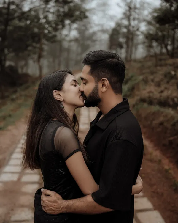 A quiet, intimate kiss shared between a couple during their pre-wedding shoot in the misty hills of Vagamon. This moody, cinematic style is perfect for capturing the deep connection between two people.