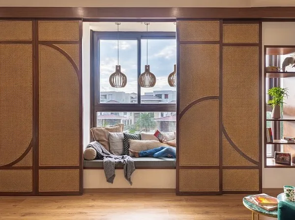 This cozy window seat is framed by custom cane and wood sliding screens. The screens offer the flexibility to create a private, enclosed nook or an open, light-filled space.