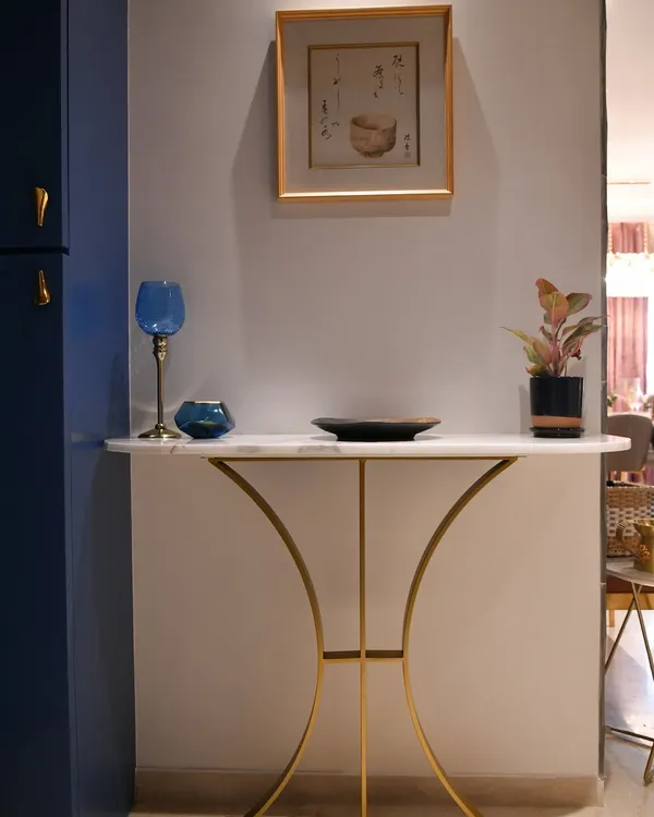 A console table is a statement piece. This design features a marble top and curved gold metal legs, perfect for an entryway. It can be styled with art, greenery, or decor to transform the vibe.