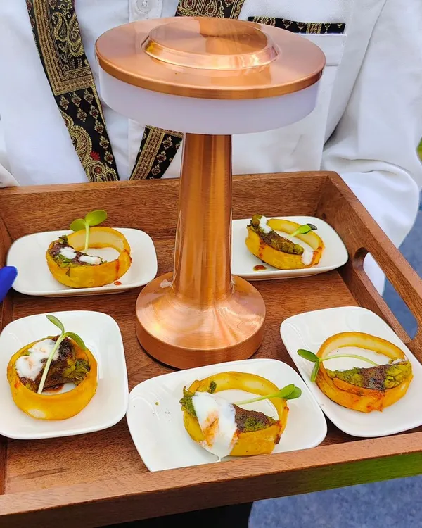 Our staff presenting potato baskets filled with savory toppings on a custom wooden tray with a built-in light. This is an example of our innovative pass-around service.