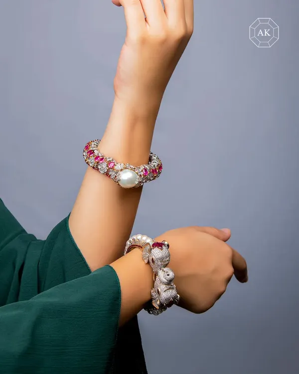 Jewellery that tells a story before you speak. This pair of 18k gold kadas is set with rare red Burmese rubies. One is sculpted with floral motifs, while the other pays homage to Indian royalty with intricately designed elephant heads.