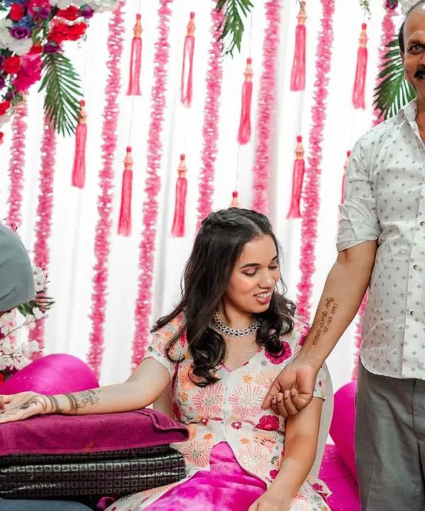 A touching moment between a father and daughter during her Mehendi ceremony. He proudly shows off a temporary tattoo of her wedding date on his arm.