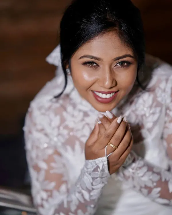 A beautiful close up of a smiling Christian bride. Her makeup is natural and radiant, with a soft lip color and defined eyes, complementing her lace gown.