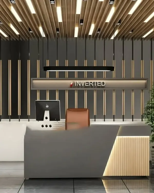 We designed this reception area to make a powerful first impression. The design features a custom-built, multi-material desk, dramatic wood slat details on the ceiling and back wall, and integrated lighting that highlights the company's branding.