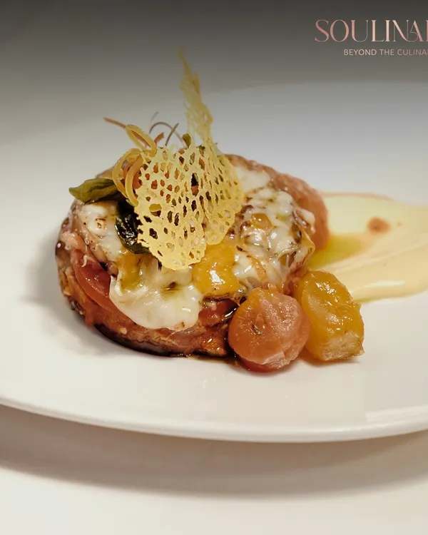 An exquisite example of modern plating, where a delicate parmesan crisp adorns a savory creation. This dish embodies our philosophy of turning food into art.
