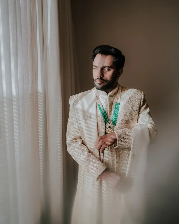 A moment of quiet anticipation for the groom. I captured this portrait of Sourav by the window, the soft light highlighting the intricate details of his sherwani and his contemplative expression.