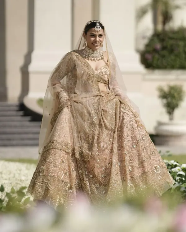 A full view of this timeless bridal look. The flowing lehenga and soft, elegant makeup come together to create a vision of understated grace, perfect for the modern bride.