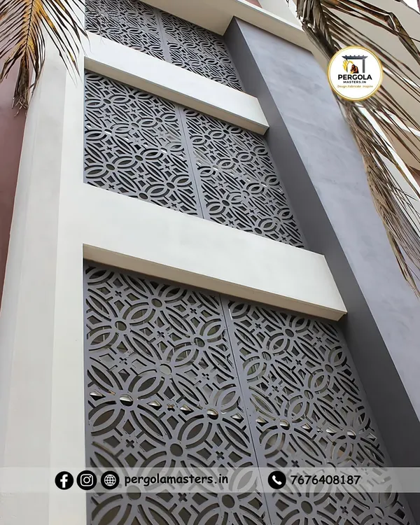 These large, laser-cut metal screens feature a traditional geometric pattern, serving as a decorative facade for a modern building. The panels add a layer of privacy and architectural interest while allowing light to filter through.
