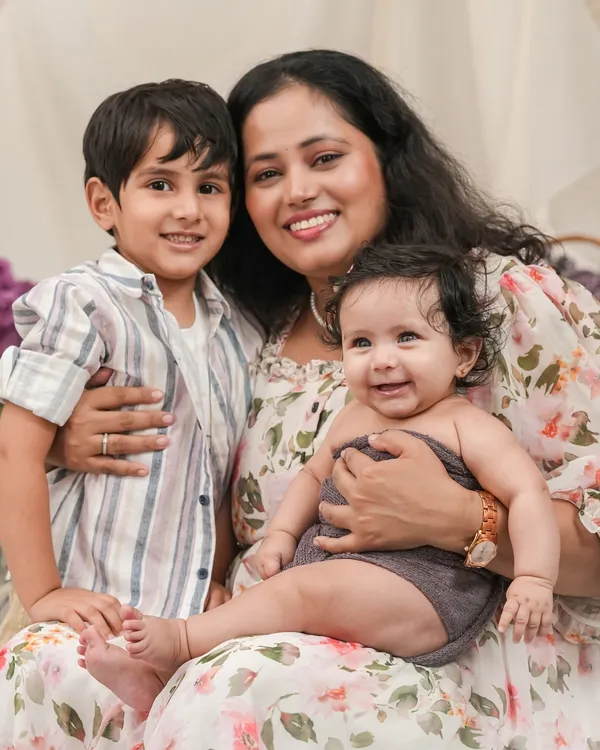 The pure joy of motherhood. This candid portrait captures a mother's love for her two children, a beautiful moment of connection and happiness.