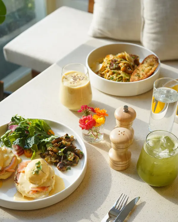 Welcome to our table. We believe in food that feels good, made with fresh, seasonal ingredients and served in a warm, light-filled space. This is what a perfect afternoon at CAARA looks like: our signature Eggs Benedict, a hearty pasta, and refreshing, house-made drinks.