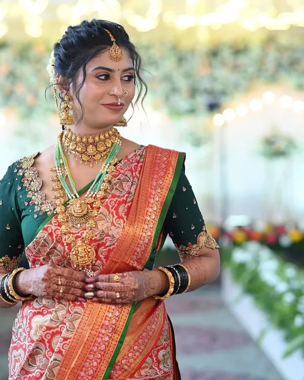 A close-up of a bride's stunning jewellery. This multi-layered temple jewellery set, including the choker, long haram, and jhumkas, is available for rent.