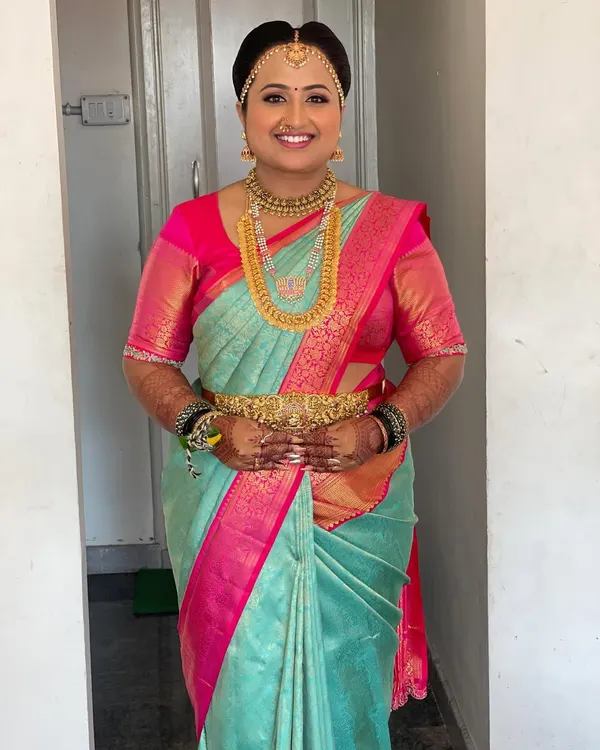 This is the quintessential South Indian bridal look I adore creating. Here, the beautiful bride Supritha is glowing for her Muhurtham, dressed in a stunning sea green and pink Kanchipuram saree. I focused on creating a flawless, radiant HD makeup base that feels light and lasts all day, paired with traditional gold temple jewellery to complete her divine look.