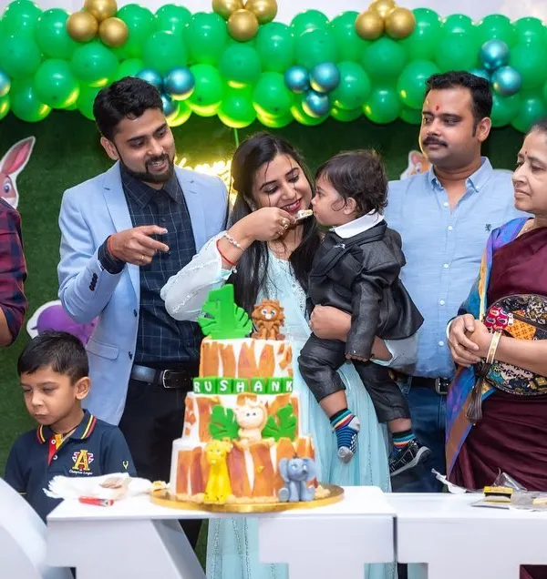 A heartwarming candid shot of a mother feeding her son his first taste of birthday cake, surrounded by smiling family members. These are the authentic, story-telling images we love to capture.