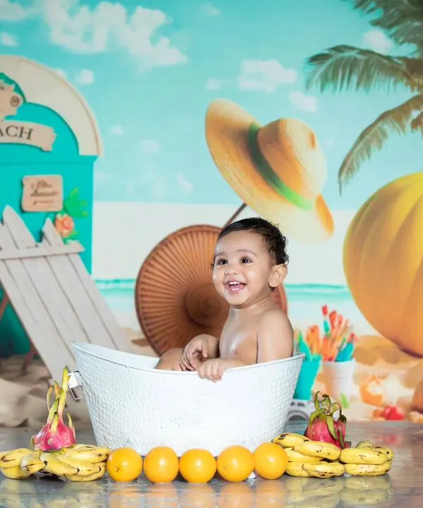Pure happiness in a tub! This beach-themed milk bath shoot is full of smiles, with bananas and oranges adding a tropical touch.