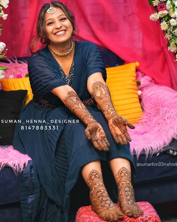 The joy on a bride's face is everything. This is why I pour my heart into every design. Here you can see a complete bridal look, with detailed henna on both the hands and feet, telling her unique wedding story with peacocks and doli motifs.