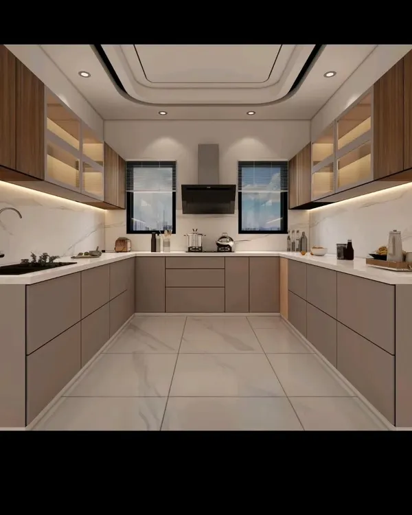 A spacious and elegant U-shaped modular kitchen I designed. It features handleless cabinets for a sleek look, a white marble backsplash, and integrated lighting under the overhead units to illuminate the countertop.