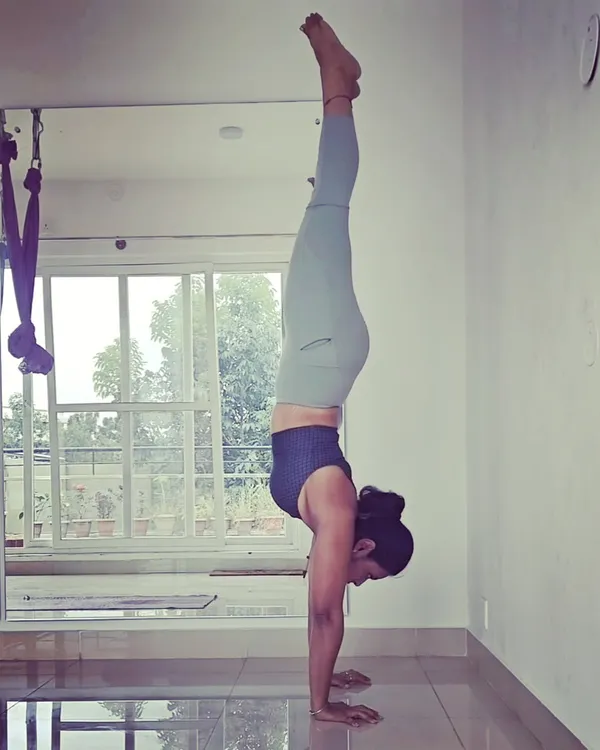 A moment of stillness, upside down. A wall-supported handstand like this is an excellent way to build the shoulder and core strength needed for freestanding inversions while getting comfortable with a new perspective.