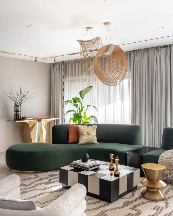 In this Santacruz duplex, we paired a deep green curved sofa with a bold checkered coffee table and sculptural brass accents. The result is a living area that feels sophisticated and cozy, with unique lighting that draws the eye and enhances the room's modern design.