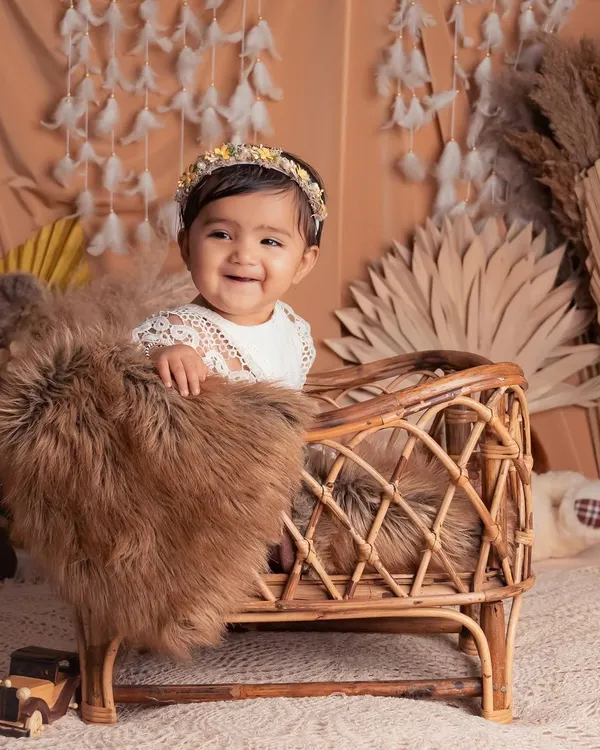 This adorable little one is all smiles in our bohemian-themed setup. The rattan bassinet, pampas grass, and feather garland create a soft, natural, and dreamy atmosphere.