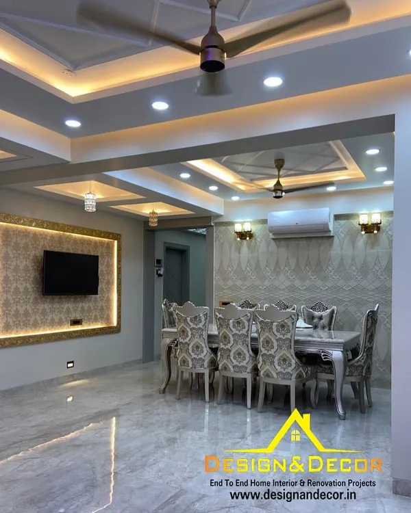 This luxurious living and dining space in Noida shows how I combine elegant design with practical living. Notice the coffered false ceiling with integrated lighting, the marble-finish flooring, and the custom TV unit, all coming together to create a grand yet welcoming atmosphere.