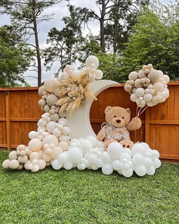 This beautiful outdoor baby shower setup is one of our favorites. We created a dreamy scene with a large moon-shaped backdrop, a cascade of boho-themed balloons in neutral and cream tones, and a plush teddy bear holding his own balloon bouquet. It’s perfect for a sophisticated and gentle "Oh Baby" celebration.
