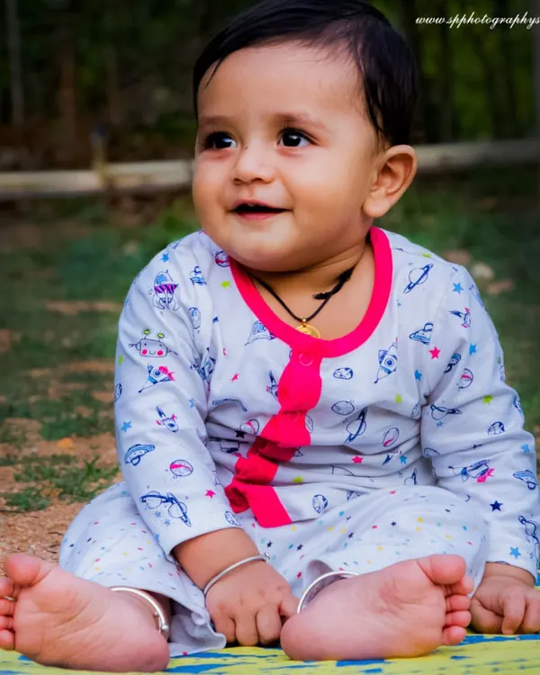 An outdoor baby photoshoot allows us to capture your little one exploring the world. This portrait of a baby sitting happily on a mat shows the simple, beautiful results of a natural light session.