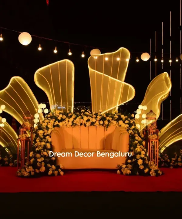 This is one of our signature stage designs, perfect for making a grand statement. We created this stunning backdrop with custom-lit abstract shapes and lush white florals for an anniversary party.